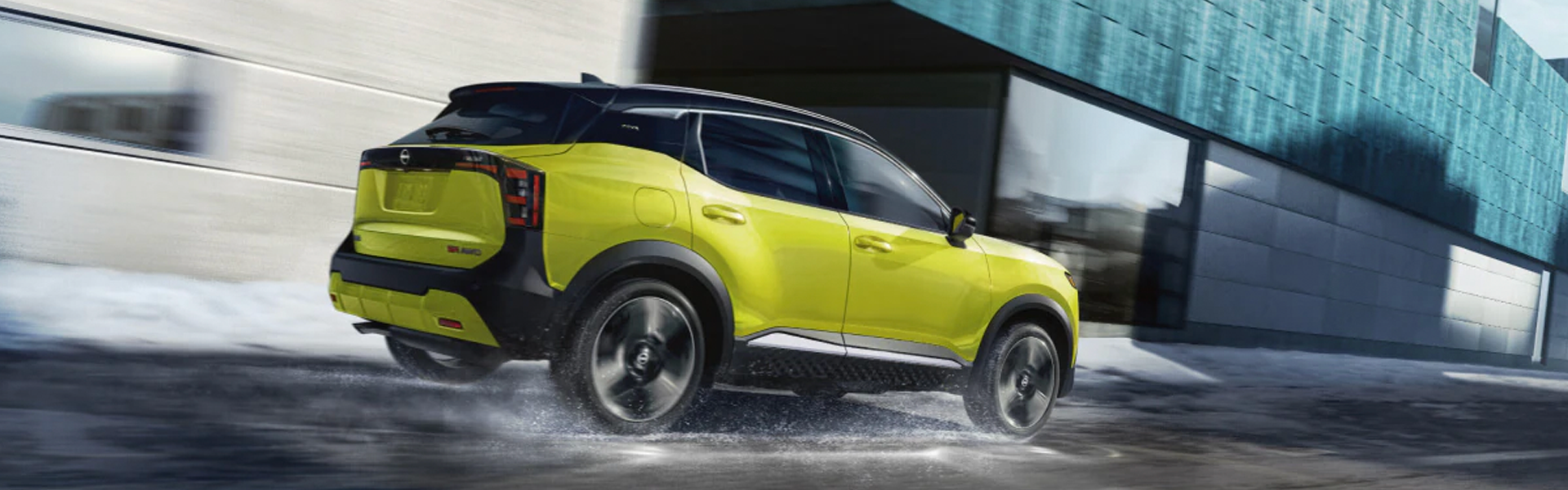 Yellow Nissan Kicks SUV driving through a city street.
